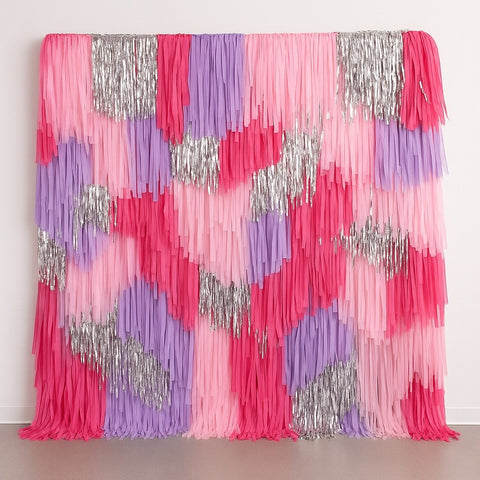 Colorful fringe backdrop with pink, purple, and silver patterns on a plain background