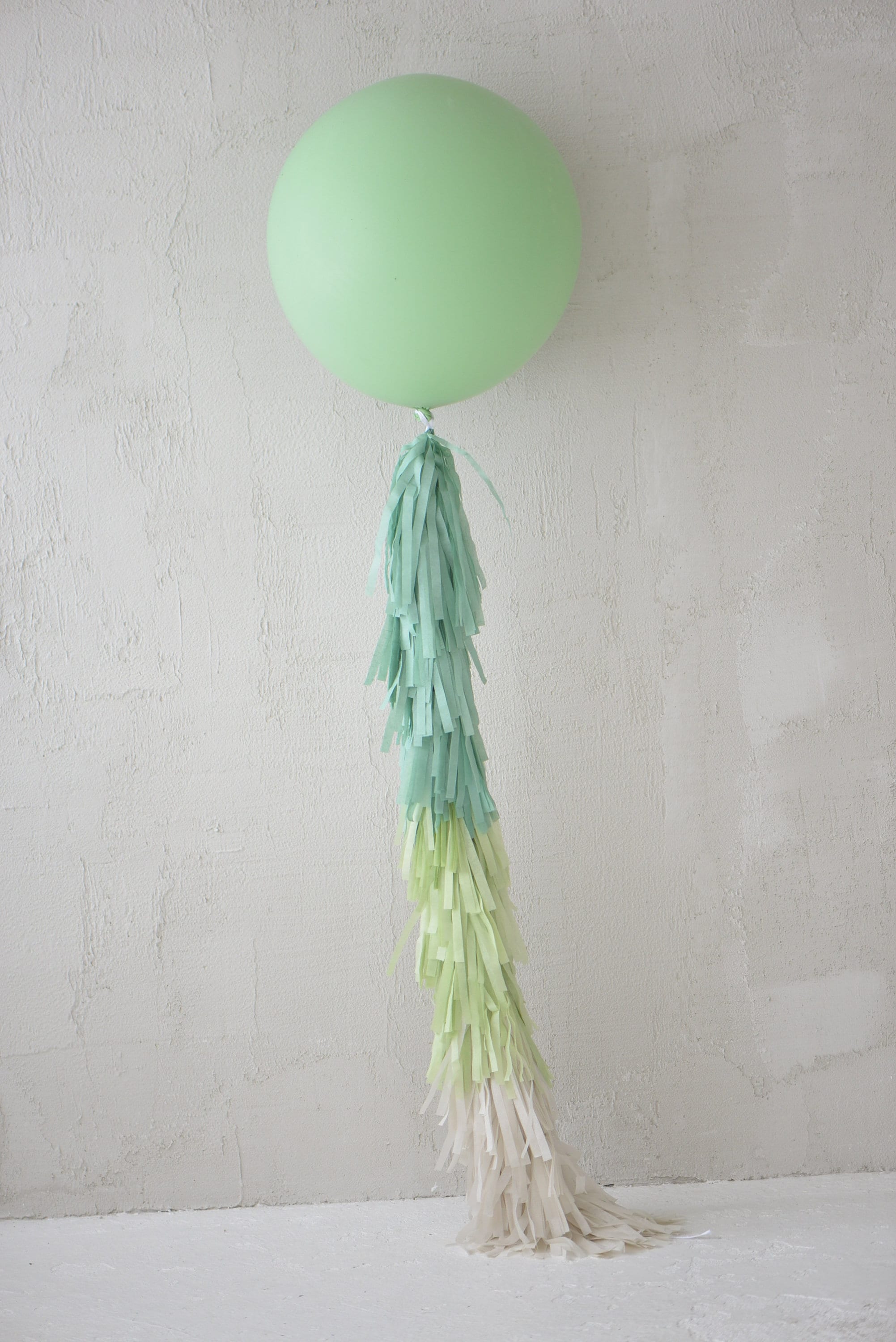 Sage green Giant balloon with green and cream paper fringe tail